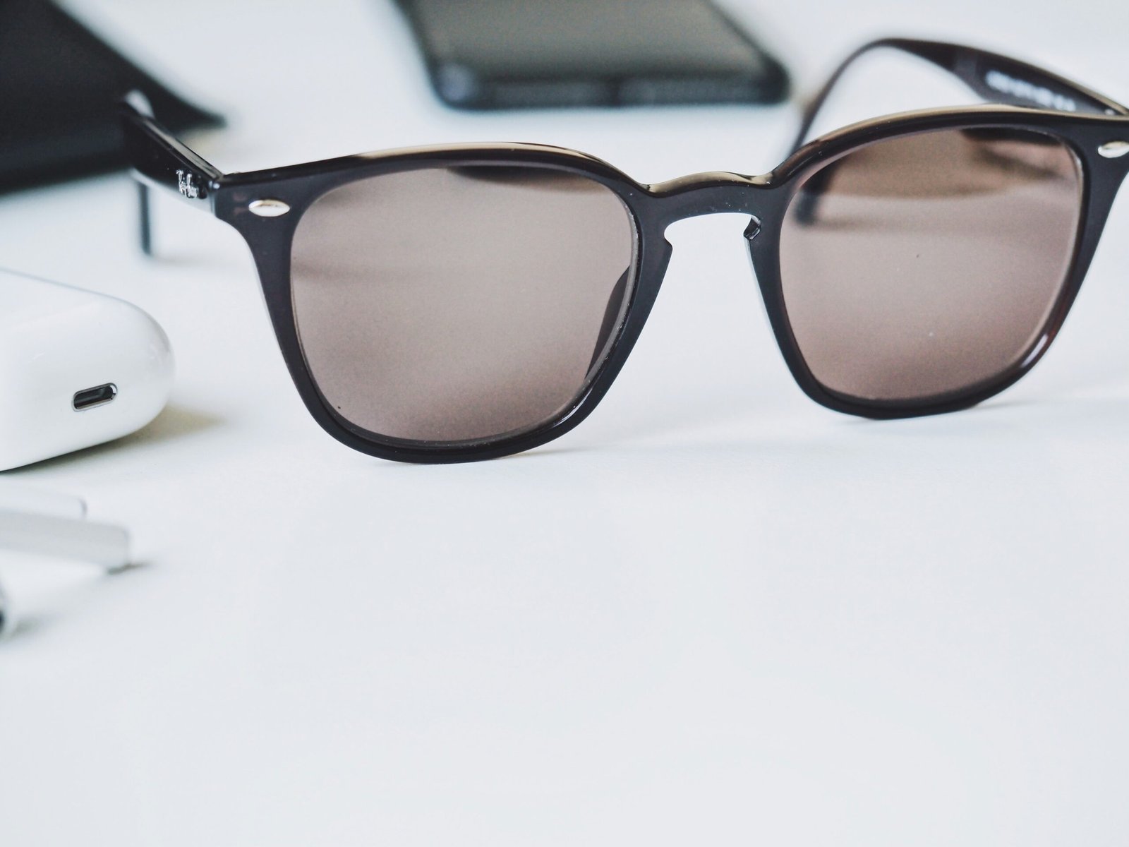 brown sunglasses on white wooden table